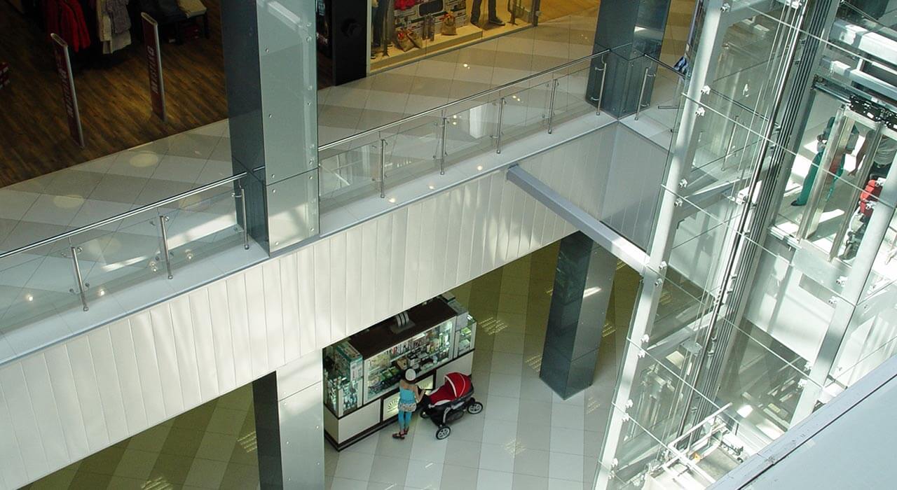 Остекление бетоных колонн окрашенным стеклом в торговом центре