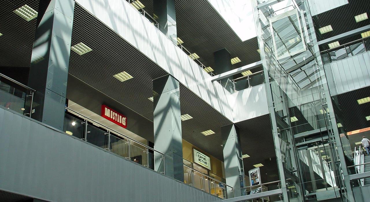 Облицовка бетоных колонн окрашенным стеклом в торговом центре